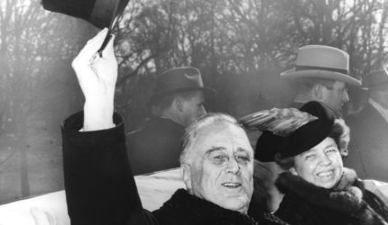 Franklin D. and Eleanor Roosevelt riding in a convertible car