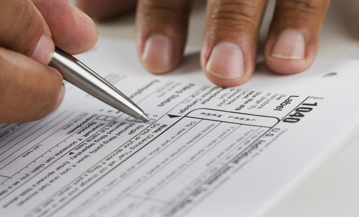 Close up of hands filling in tax form